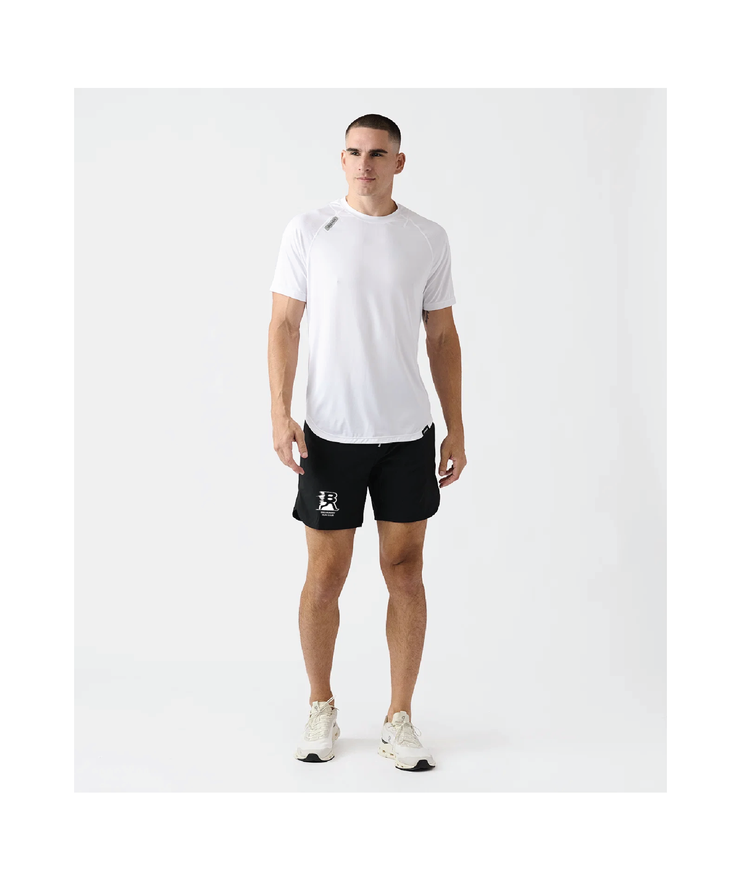 Man wearing a white t-shirt and black shorts on a white background