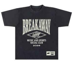 A black short-sleeve t-shirt with a vintage-style cream graphic print on the front. The graphic features the text 'BREAKAWAY' in a large arched font, a diamond logo reading 'Garage Beer', and 'MUSIC AND SPORTS SOCIAL CLUB 2026'.