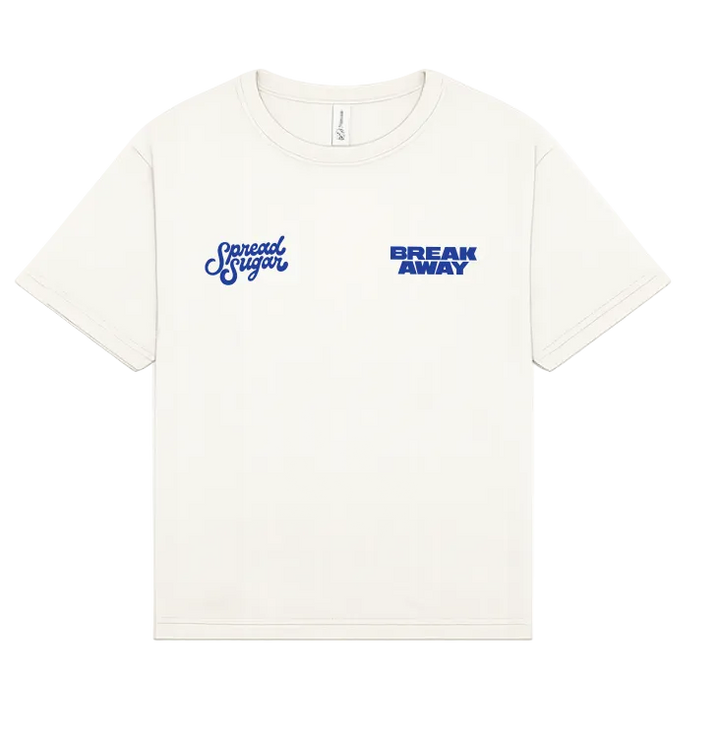 An off-white short-sleeve crewneck t-shirt with blue graphic text on the chest. On the wearer's left chest is the cursive script 'Spread Sugar', and on the right chest is the block text 'BREAK AWAY'.